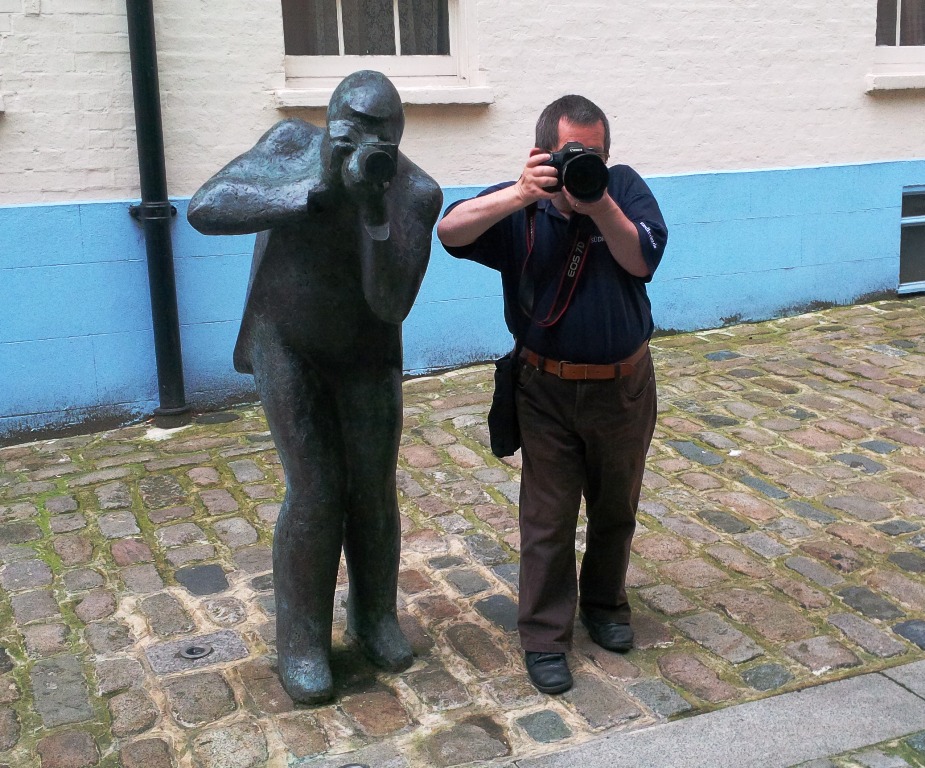 Fotograf (rechts) neben einer Fotografen-Statue (links)